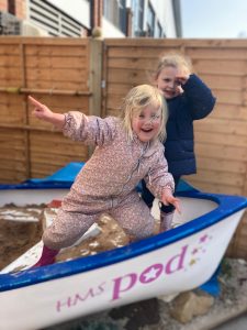 children in a sandpit boat
